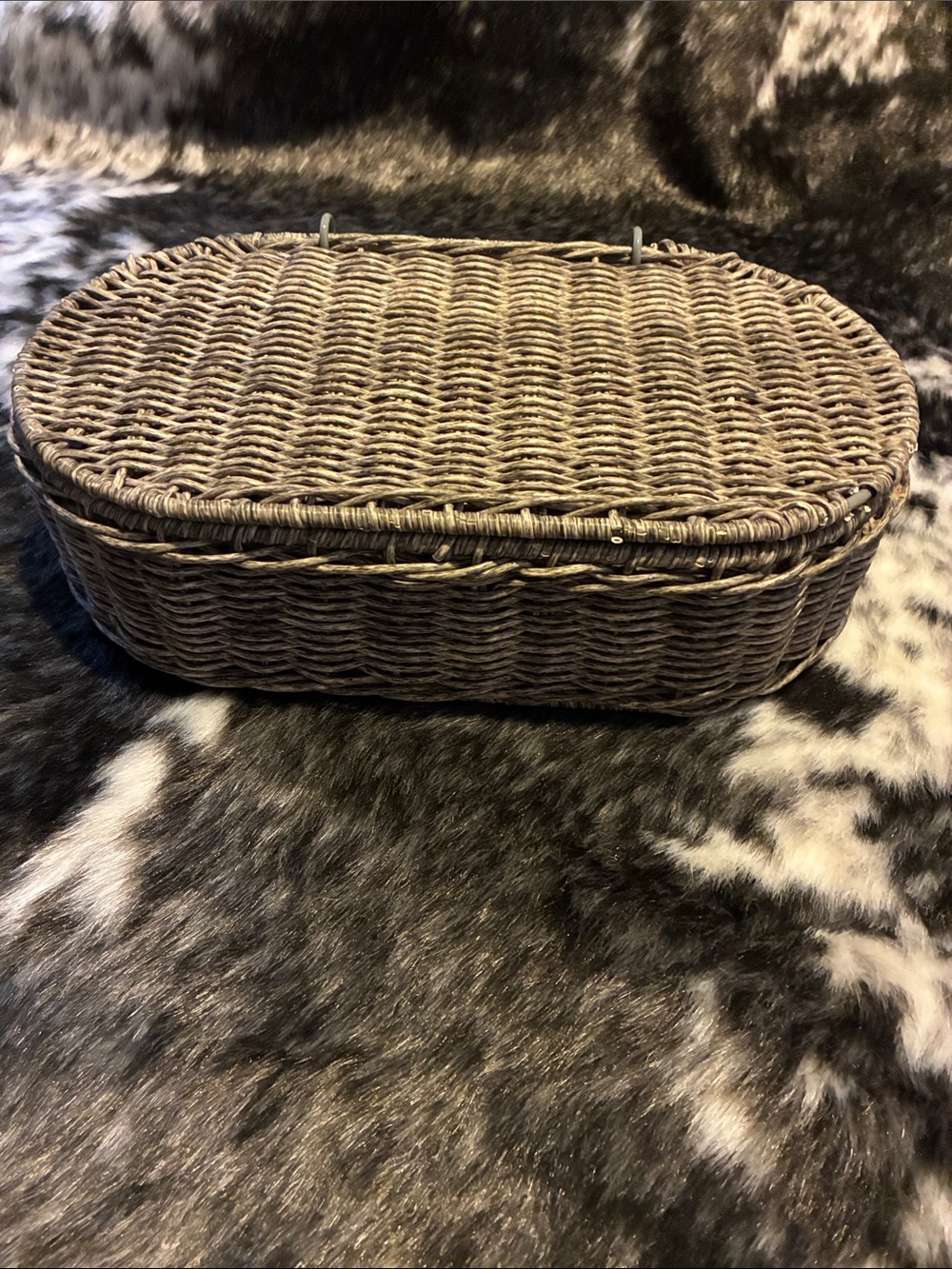 Vintage oval wicker basket with a hinged lid.